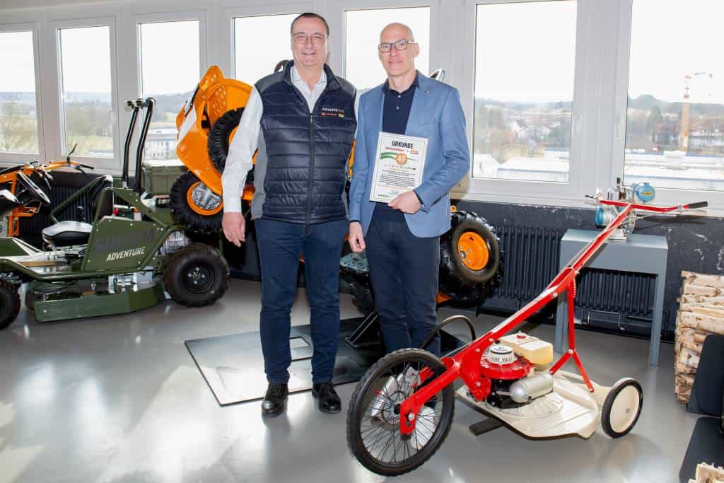 Jochen Schneider (rechts), Executive Vice President AriensCo EMEAA übergibt die Urkunde für 40 Jahre Partnerschaft an Geschäftsführer Ronald Hrnecek (links).