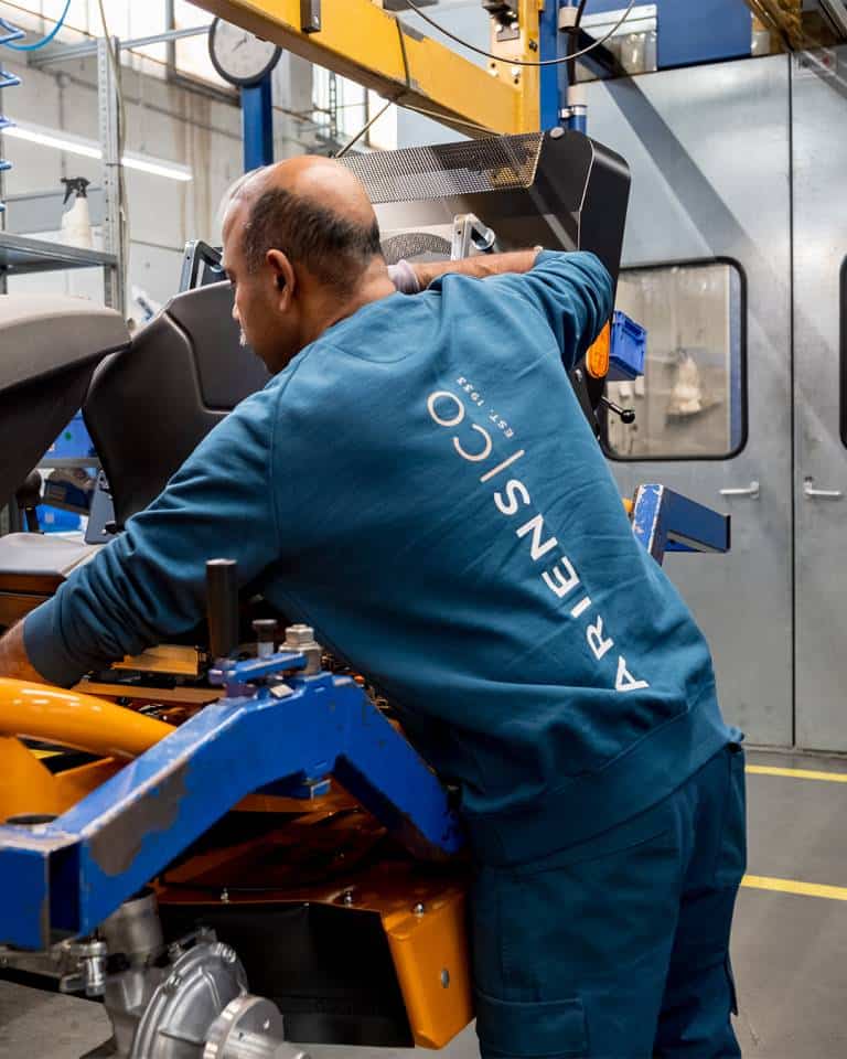 Factory worker of AriensCo EMEAA wearing their new turquise work wear inside their factory in Bühlertann, Germany